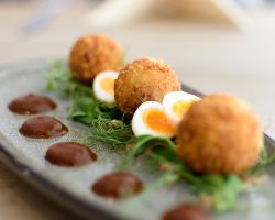 Deep fried ham hock bonbons served with homemade brown sauce, quail’s egg, pea shoots and honey and mustard dressing Deep fried ham hock bonbons served with homemade brown sauce, quail’s egg, pea shoots and honey and mustard dressing