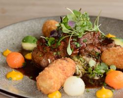 Oven roasted lamb rump served with rosemary potato croquettes, carrot purée, vegetable pearls, savoy cabbage and minted jus Oven roasted lamb rump served with rosemary potato croquettes, carrot purée, vegetable pearls, savoy cabbage and minted jus