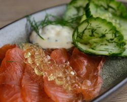Salmon home cured in gin, served with tonic and lime caviar, dill and cucumber salad and a chive crème fraîche Salmon home cured in gin, served with tonic and lime caviar, dill and cucumber salad and a chive crème fraîche