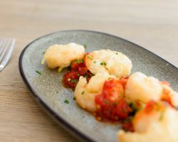 Tempura battered king prawns served with a salad of spring onion, fresh chilli, coriander and drizzled with homemade sweet chilli sauce Tempura battered king prawns served with a salad of spring onion, fresh chilli, coriander and drizzled with homemade sweet chilli sauce