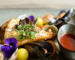 Pan fried fillet of turbot served with a medley of king prawns, mussels and clams, saffron potato pearls, sugar snap peas and a rich bouillabaisse sauce Pan fried fillet of turbot served with a medley of king prawns, mussels and clams, saffron potato pearls, sugar snap peas and a rich bouillabaisse sauce