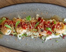 King prawns cooked in a chilli and garlic butter, served with an oriental style salad, toasted sesame seeds and homemade sweet chilli sauce King prawns cooked in a chilli and garlic butter, served with an oriental style salad, toasted sesame seeds and homemade sweet chilli sauce