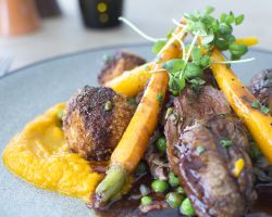 Pan roast 7oz lamb rump served with a shepherd’s pie croquette potato, sautéed bacon, peas and shallots, roasted carrot purée, baby carrots and a minted red wine jus Pan roast 7oz lamb rump served with a shepherd’s pie croquette potato, sautéed bacon, peas and shallots, roasted carrot purée, baby carrots and a minted red wine jus